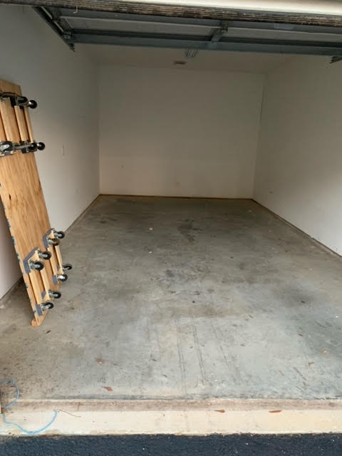 Parcstone Apartments in Fayetteville An empty garage with a skateboard on the floor in apartments with garages.