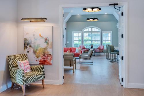 Apartments in Fayetteville, North Carolina Stylish living room with modern decor, abstract wall art, a patterned chair, and large windows providing natural light. Parcstone Apartments For Rent in Fayetteville