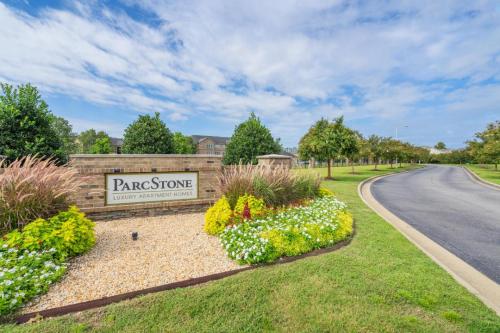 Apartments in Fayetteville, North Carolina Entrance to ParcStone Luxury Apartment Homes with sign, landscaped flowers, and a road leading into the complex. Parcstone Apartments For Rent in Fayetteville