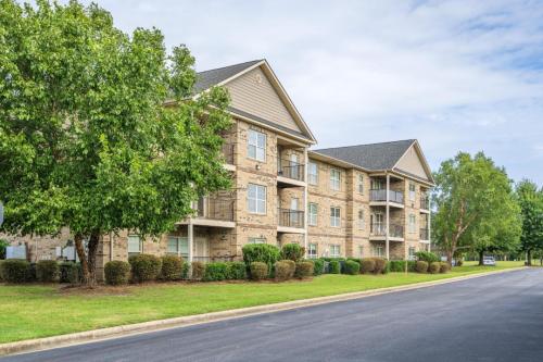 Apartments in Fayetteville, North Carolina A three-story brick apartment building with balconies, surrounded by green lawns and trees. Parcstone Apartments For Rent in Fayetteville